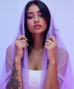 Photograph-of-a-beautiful-woman-with-long-dark-hair-wearing-a-white-dress-purple-veil-and-intricate-tattoos