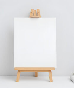 Photograph-of-a-blank-white-canvas-on-a-wooden-easel-flanked-by-two-white-pots-with-green-plants-white-shoes
