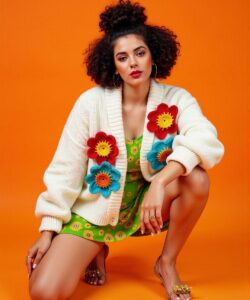 This-is-a-high-resolution-photograph-featuring-a-young-woman-with-a-medium-complexion-and-curly-dark-hair-styled-in-a-voluminous-top-knot-She-is-kneeling-on-one-knee-with-her-right-leg-bent-and-her
