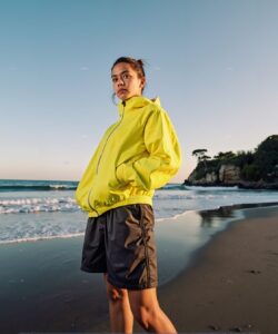 This-is-a-high-resolution-photograph-taken-at-a-beach-during-the-golden-hour-the-time-shortly-before-sunset-or-after-sunrise-when-the-light-is-soft-and-warm-The-main-subject-is-a-young-woman-standing-on