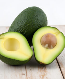 A-photograph-of-an-avocado-with-half-opened-fruit-and-a-whole-one-on-a-rustic-wooden-surface