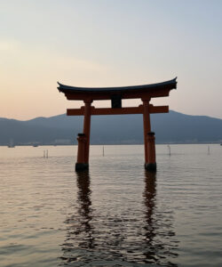 A-serene-photograph-of-a-traditional-Japanese-torii-gate-silhouetted-against-a-calming-sunset-over-a-tranquil-lake