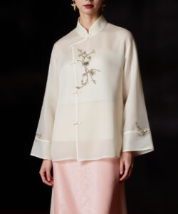Asian woman in traditional white silk robe with gold embroidery pink silk skirt dark background studio portrait elegant