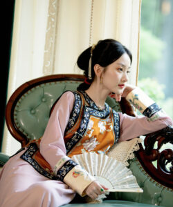 Asian woman sitting on an antique chair traditional clothing hand fan elegant soft lighting high quality photo watermark