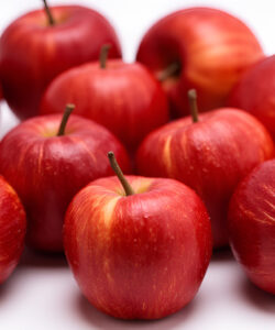 Close-up-photograph-of-vibrant-red-apples-with-hints-of-yellow-and-green-arranged-in-a-loose-overlapping-cluster-on-white