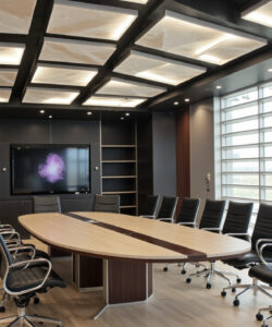 Modern-conference-room-with-a-large-oval-wooden-table-black-chairs-floor-to-ceiling-windows-black-walls-and-recessed-ceiling-lights
