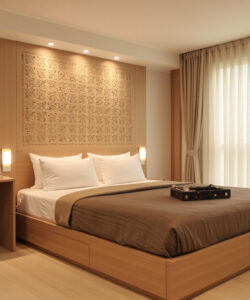 Modern-hotel-room-with-a-wooden-bed-beige-curtains-desk-and-a-chair-photograph-minimalist-design-warm-lighting