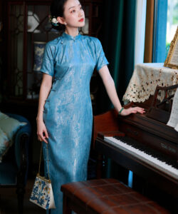 Photo of an asian woman in a blue silk cheongsam dress standing next to a piano watermark