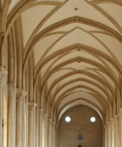 Photograph-of-a-Gothic-style-cathedral-interior-with-tall-arched-ceilings-stone-columns-and-large-circular-stained-glass-windows