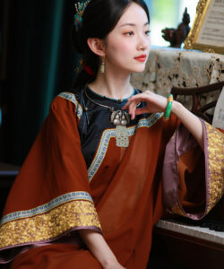Photograph of a fair skinned dark haired asian woman in a traditional ornate brown and gold dress seated at a piano