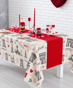 Photograph-of-a-festive-table-adorned-with-red-and-black-Eiffel-Tower-patterned-tablecloth-wine-glasses-and-red-candles