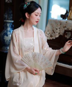 Photograph of a serene asian woman in traditional cream silk robe holding a fan playing piano in elegant room