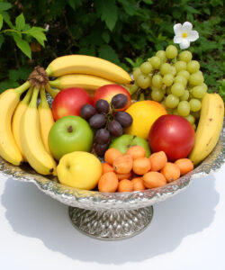 Photograph-of-a-silver-ornate-bowl-filled-with-various-fruits-including-bananas-apples-grapes-pears-and-oranges-set-outdoors