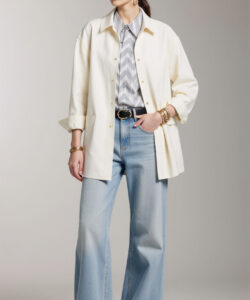 Photograph of a stylish light skinned woman in a beige hat light blue jeans white shirt and cream jacket
