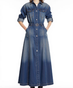 Photograph of a young woman in a long blue denim dress with sleeves rolled up black boots and sunglasses