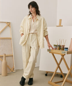 Artists Style Woman In Cream Overalls By Easel