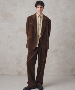Brown Suede Suit Curly Haired Man Against Textured Wall