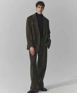 Caucasian Man In A Dark Brown Suede Suit With Gold Trim Black Turtleneck And