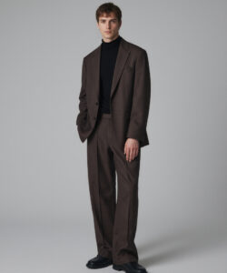 Caucasian Man With Short Brown Hair Wearing A Dark Brown Suit Black Turtleneck And