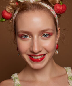 Caucasian Woman With Blue Eyes Blonde Hair In Buns Strawberry Headband Red Lips Green