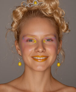 Blonde Woman With Curled Hair Wearing A Silver Tiara Yellow And Purple Makeup And