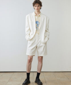 Curly Haired Man In A White Suit Suit Black Socks And Black Shoes Standing