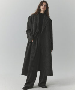 Haired Woman In A Dark Oversized Oversized Coat And Matching Pinstripe Pants