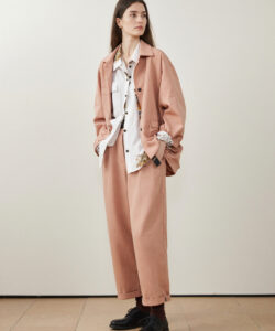 Haired Woman In Oversized Pastel Pink Suit Suit Over White Shirt Black Shoes Hands