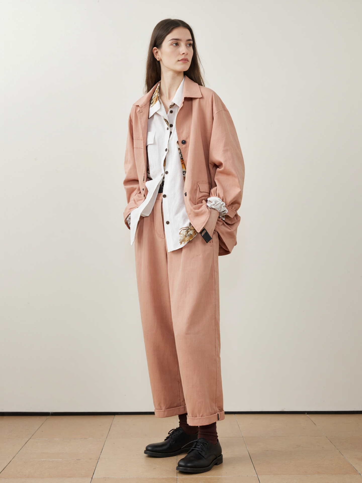 Haired Woman In Oversized Pastel Pink Suit Suit Over White Shirt Black Shoes Hands