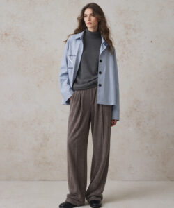 Light Skinned Woman With Long Brown Hair Wearing A Light Blue Jacket Gray Sweater