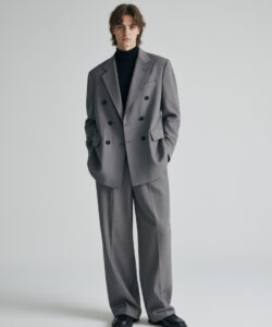 Man In A Grey Double Breasted Suit Suit Black Turtleneck Hands In Pockets Standing