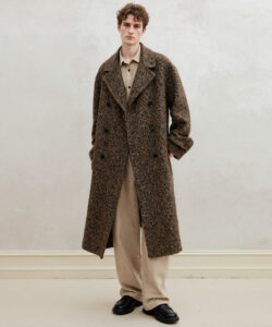 Man In A Long Brown Herringbone Patterned Overcoat Beige Shirt And Pants