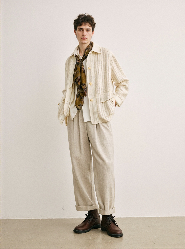 White Man With Curly Hair Wearing Beige Striped Jacket Patterned Scarf White Shirt And