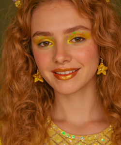 Woman With Curly Red Hair Yellow Star Earrings Glittery Yellow Eyeshadow And A Yellow 1