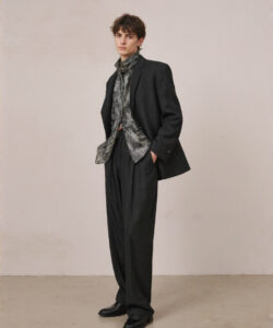 Young White Man In A Dark Grey Grey Suit Scarf And Black Shoes Standing